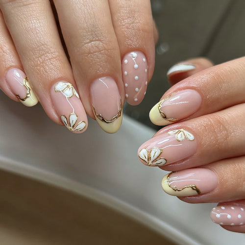 Kunstvolle Nagelverlängerungen mit floralem Design und eleganten Goldakzenten Karnz