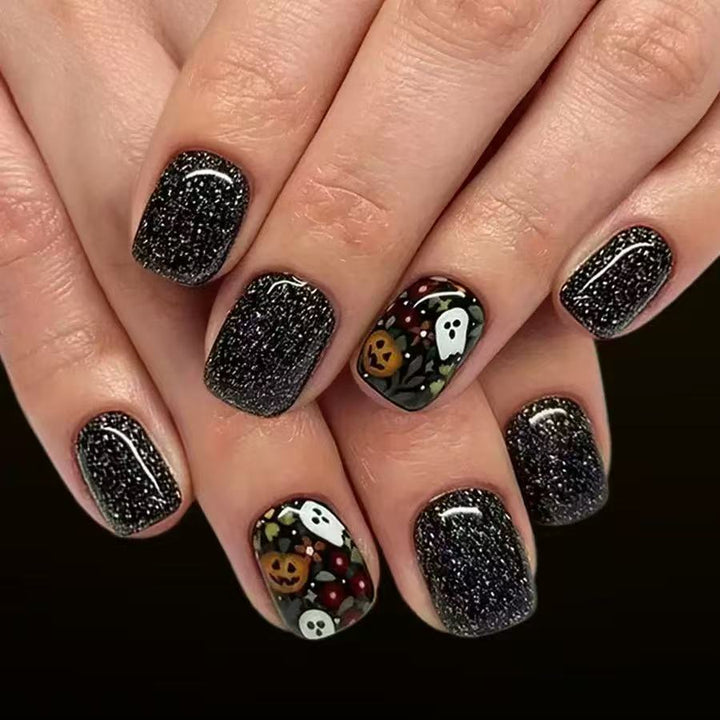 Kunstnagelset mit Halloween-Motiven und Glitzerakzenten Karnz