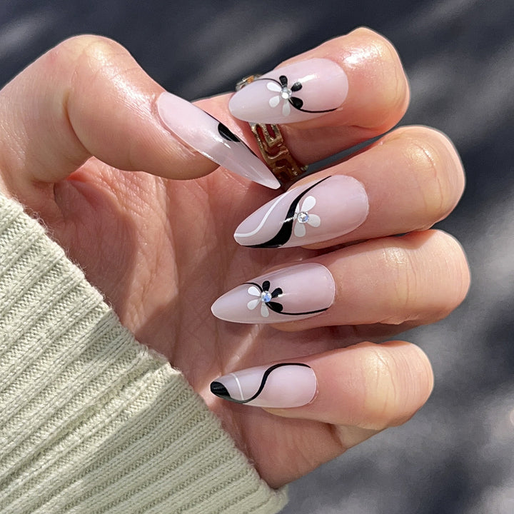 Kunstvolle Nagelverlängerungen mit floralen Akzenten und Glitzerakzenten Karnz