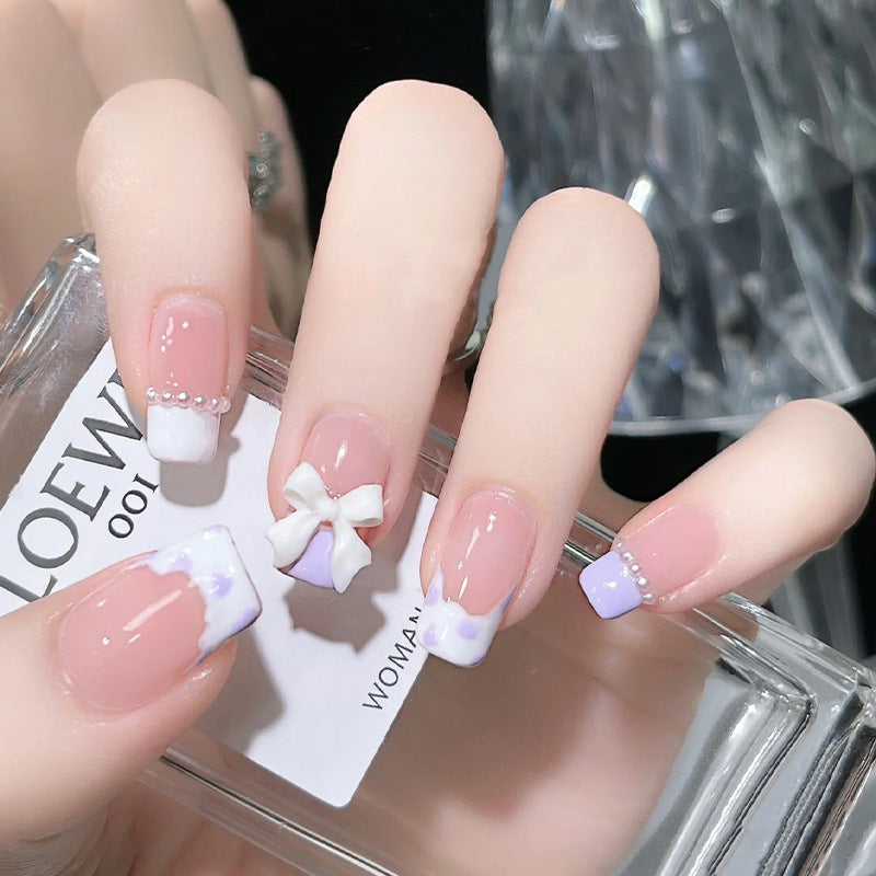 Kunstnagelset mit eleganten Wellenmustern und zarten Perlenakzenten Karnz