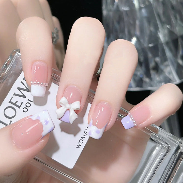 Kunstnagelset mit eleganten Wellenmustern und zarten Perlenakzenten Karnz