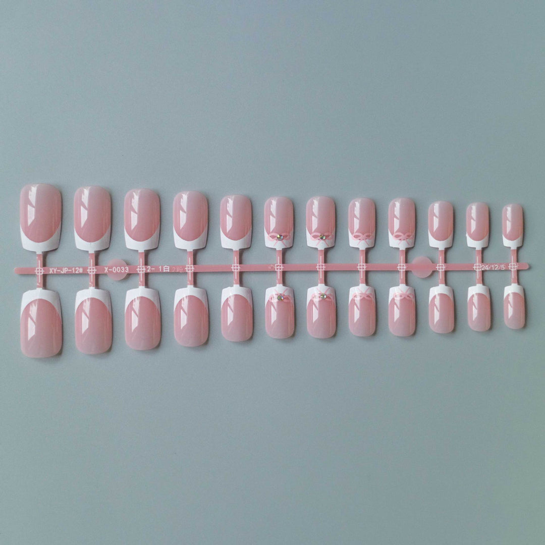 Elegantes French Tip Nagelkunstset mit zarten Schleifenakzenten