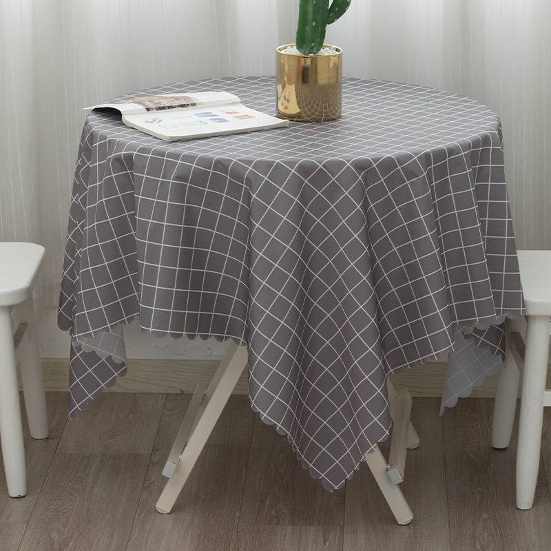 Runde abwaschbare Tischdecke mit feinem Karo‑Gittermuster und welligem Saum