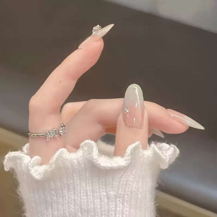 Kunstnägel mit zartem Ombre-Design und filigranen Verzierungen