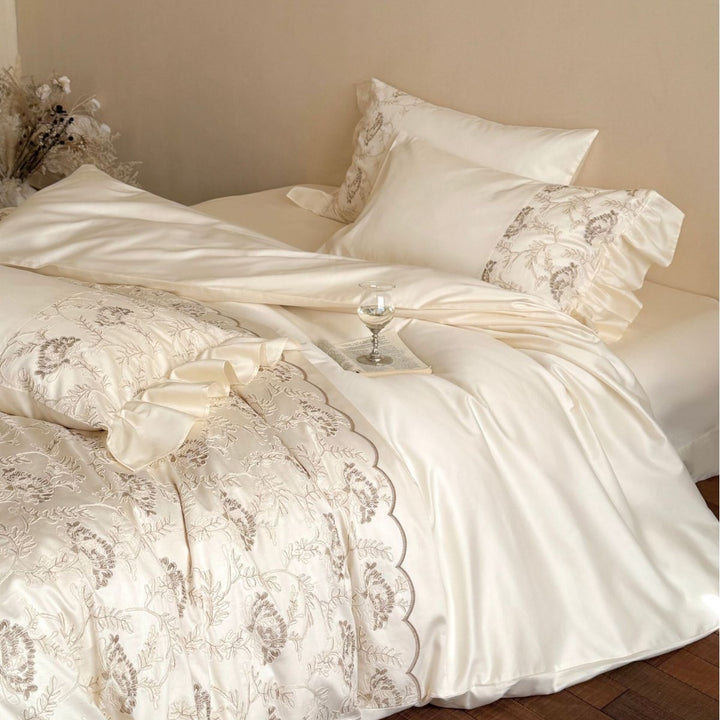 Steppbett mit floraler Stickerei, Satinvolant und dekorativer Biese