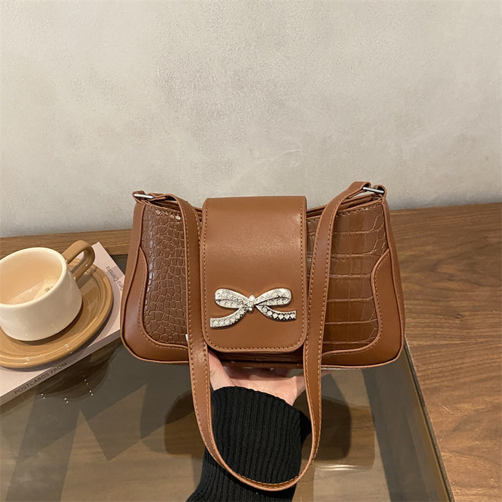 Elegante Handtasche mit Krokodilmuster und Schleifendetail