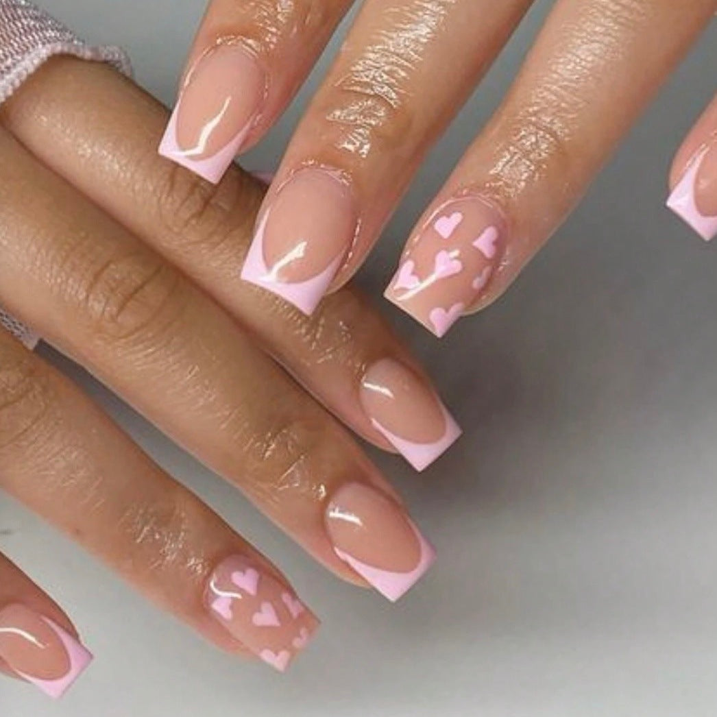 Kunstnagelset mit romantischen Herzmotiven und elegantem French Design Karnz