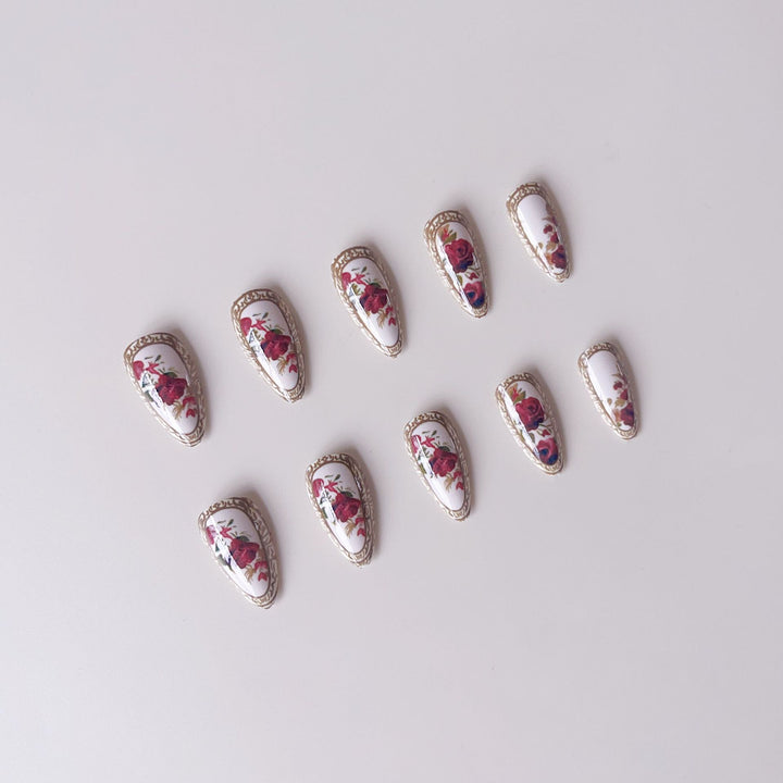 Kunstnagelset mit luxuriösem Blumenmuster und goldenen Akzenten Karnz