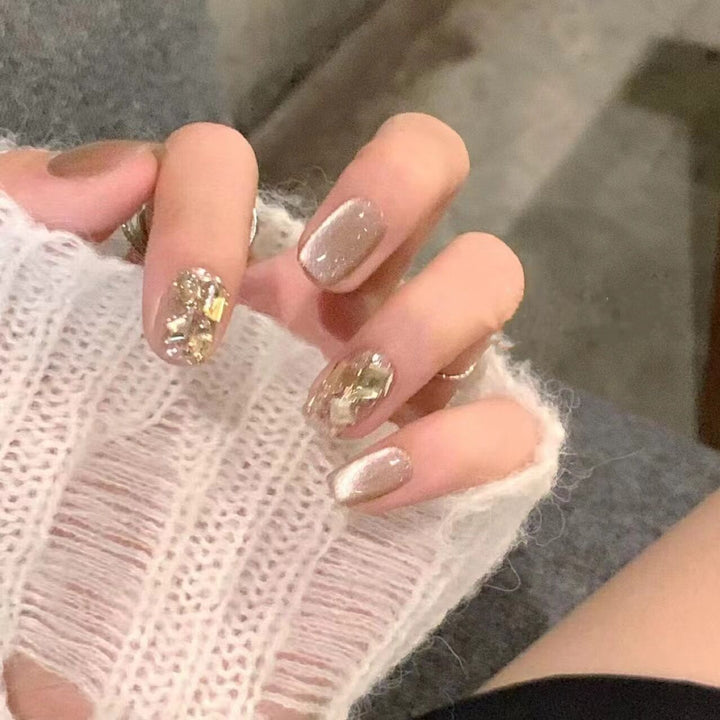 Kunstnagelset mit elegantem Glitzermuster und goldenen Akzenten Karnz