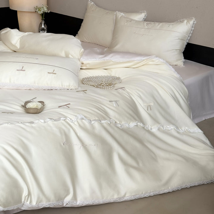 Elegante Bettwäschegarnitur aus seidig-feinem Satin mit bestickten Schleifen und Spitzenbordüre