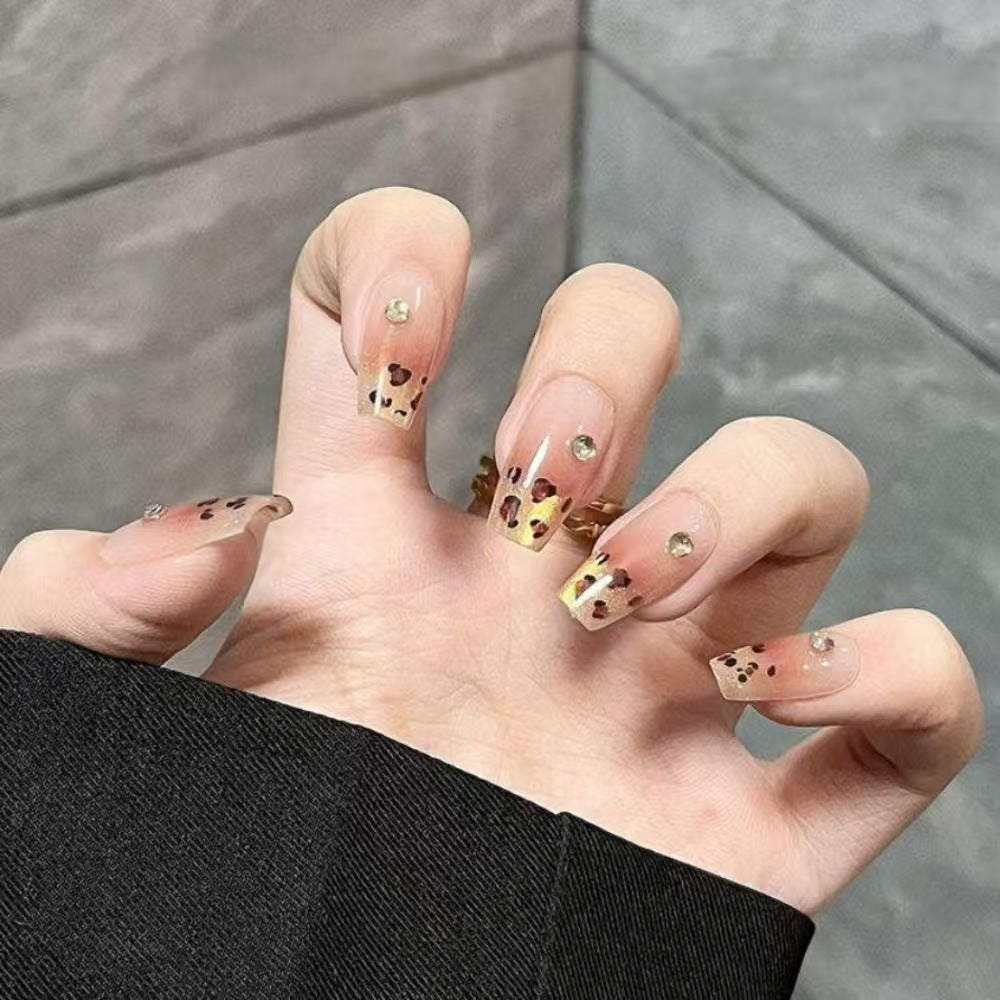 Kunstnägel mit Eleganten Leo-Muster und Glitzerakzenten Karnz