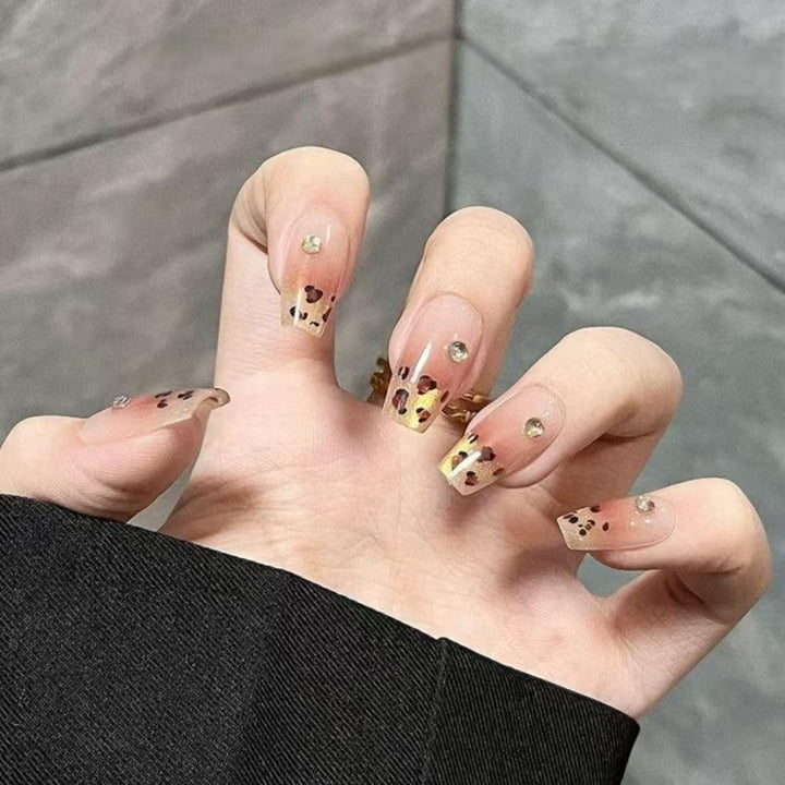 Kunstnägel mit Eleganten Leo-Muster und Glitzerakzenten Karnz