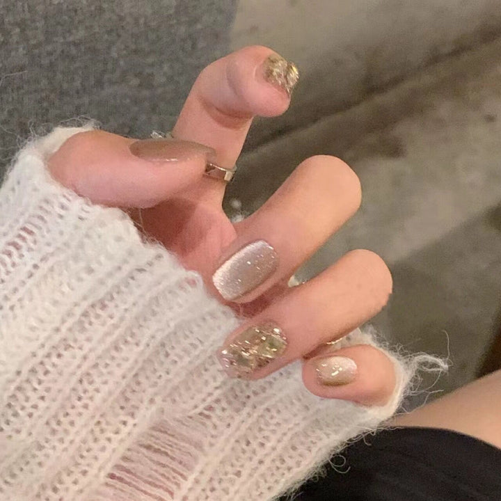 Kunstnagelset mit elegantem Glitzermuster und goldenen Akzenten Karnz