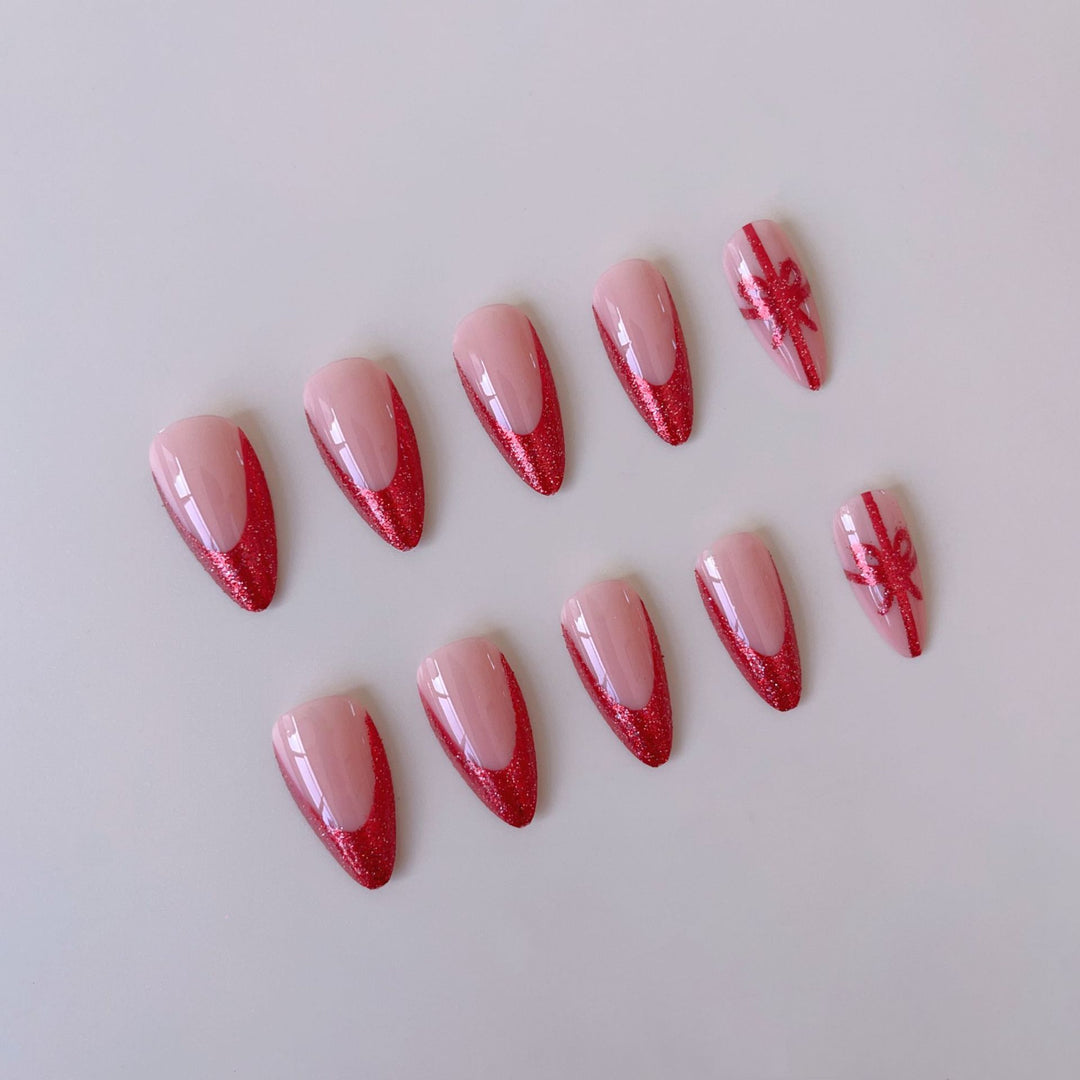 Kunstnagelset mit glamourösen Glitzer-Akzenten und Schleifen-Design Karnz