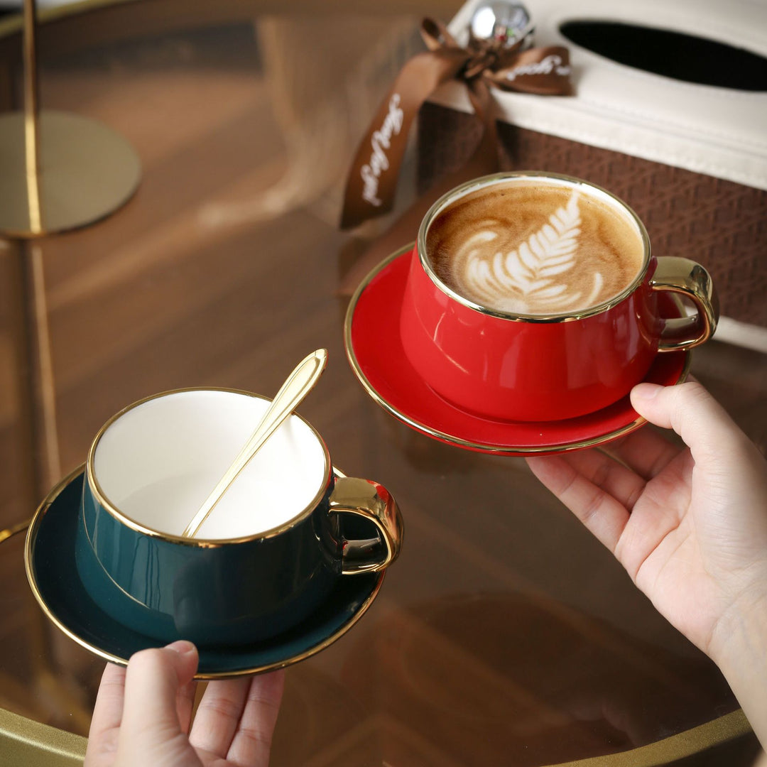 Elegante Porzellan-Tasse mit Untertasse und skulpturellem Goldhenkel