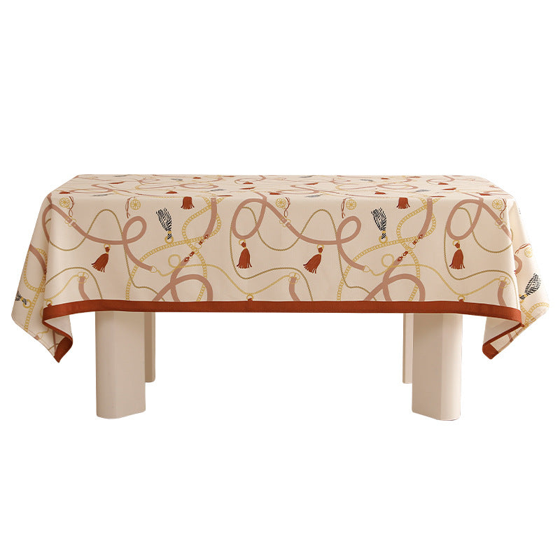 Rechteckige Tischdecke aus pflegeleichtem Polyester‑Mischgewebe mit dekorativem Quasten‑ und Bandmotiv und kontrastierter Saum