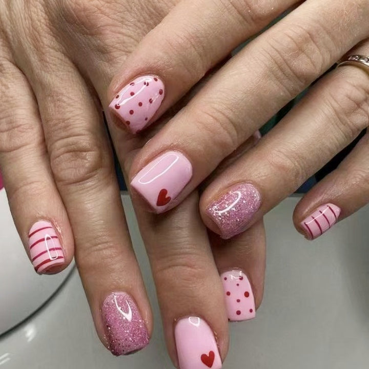 Kunstnagelset mit romantischen Herzmotiven und glitzernden Akzenten Karnz