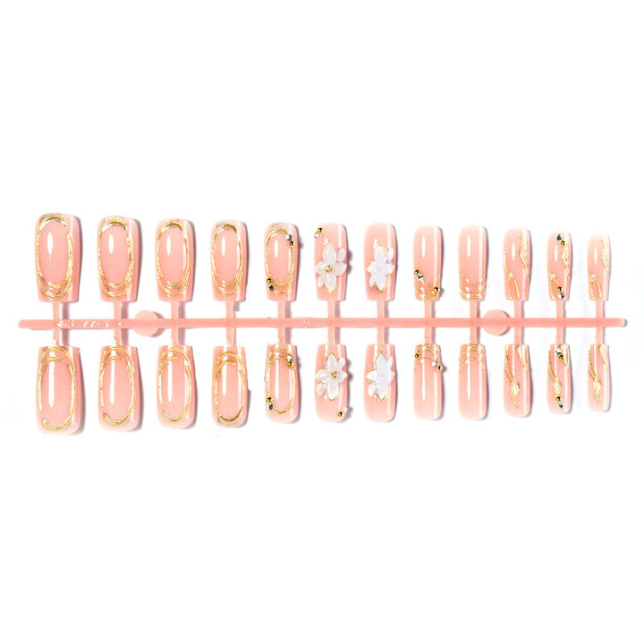 Kunstnagelset mit floralen Verzierungen und goldenen Akzenten Karnz