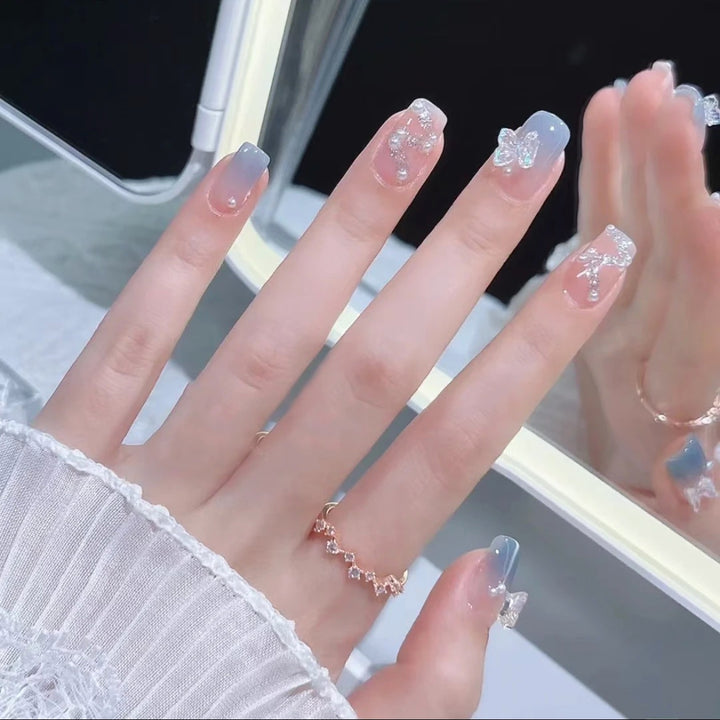 Kunstvolle Nagelverzierung mit Glitzer- und Schmetterlingsdetails Karnz