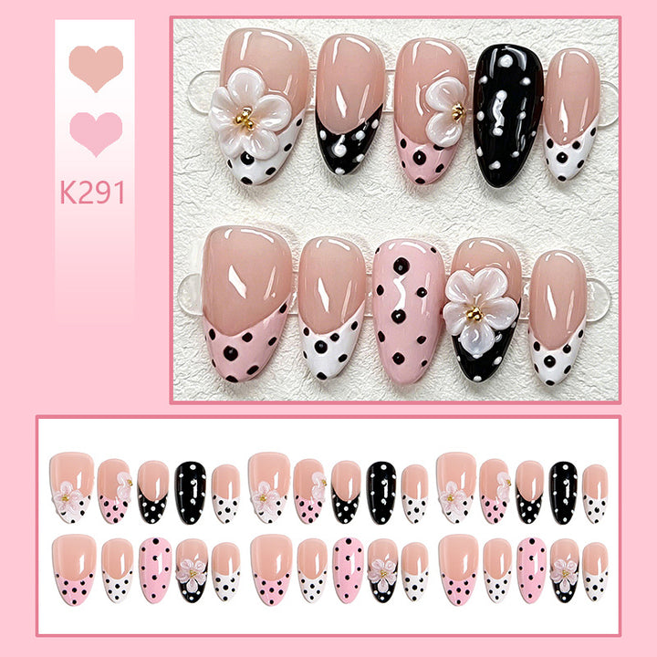 Kunstnagelset mit blumigen Akzenten und eleganten Punkten Karnz