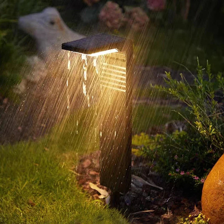 Spritzwassergeschützte Solarleuchte mit Lichtstrahl auf feuchtem Rasen
