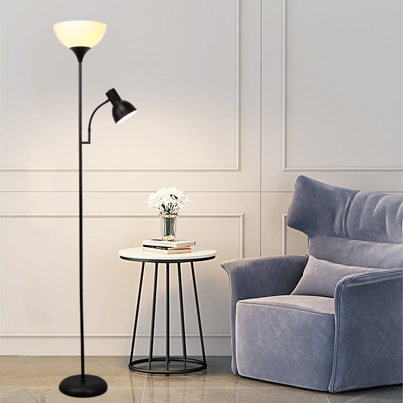 Stehlampe mit weißem Schirm und Leselicht neben blauem Sessel und rundem Beistelltisch