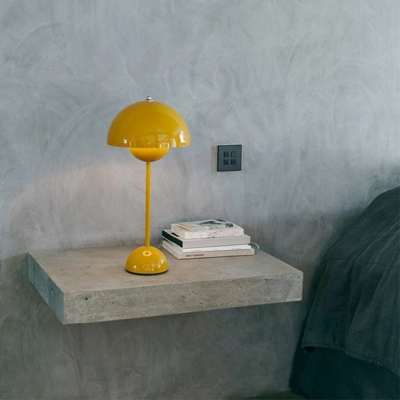 Gelbe Designlampe auf grauer Kommode mit Buch