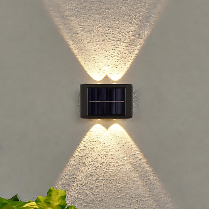 Einzelne LED-Solarwandleuchte mit Licht nach oben und unten an weißer Außenwand