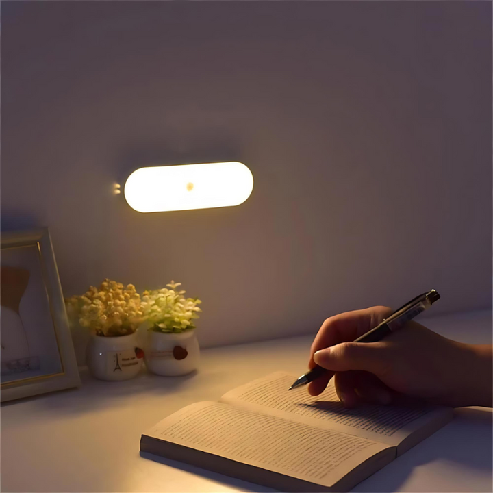 LED-Nachtlicht an der Wand über Tisch mit Blumen und Hand, die schreibt

