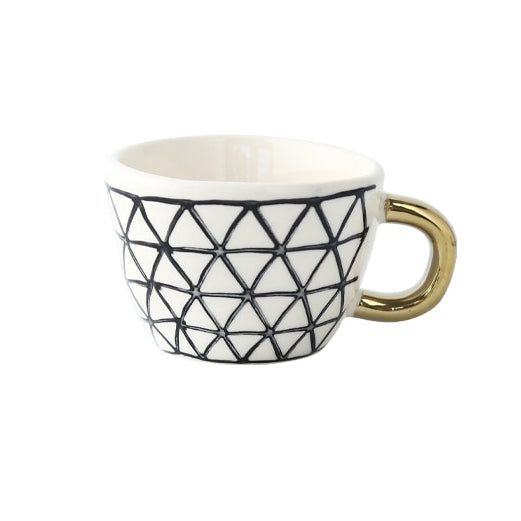Tasse mit abstraktem geometrischen Muster und goldenem Henkel
