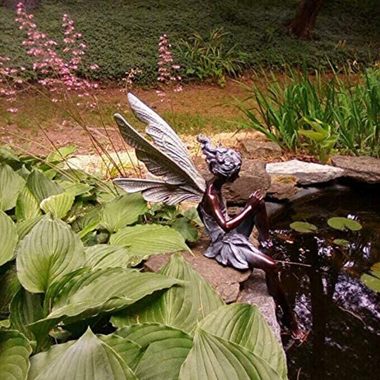Statue einer sitzenden Fee im Garten