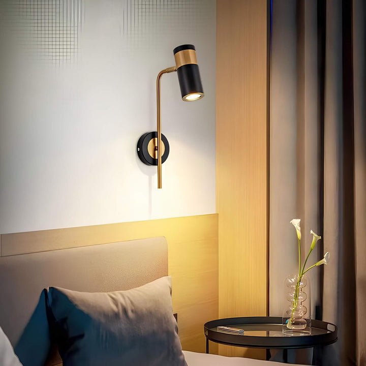 Goldene Wandleuchte mit schwarzem Schirm neben Bett und rundem Nachttisch
